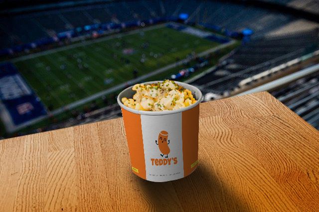 A Teddy's pasta cup on a ledge overlooking a stadium